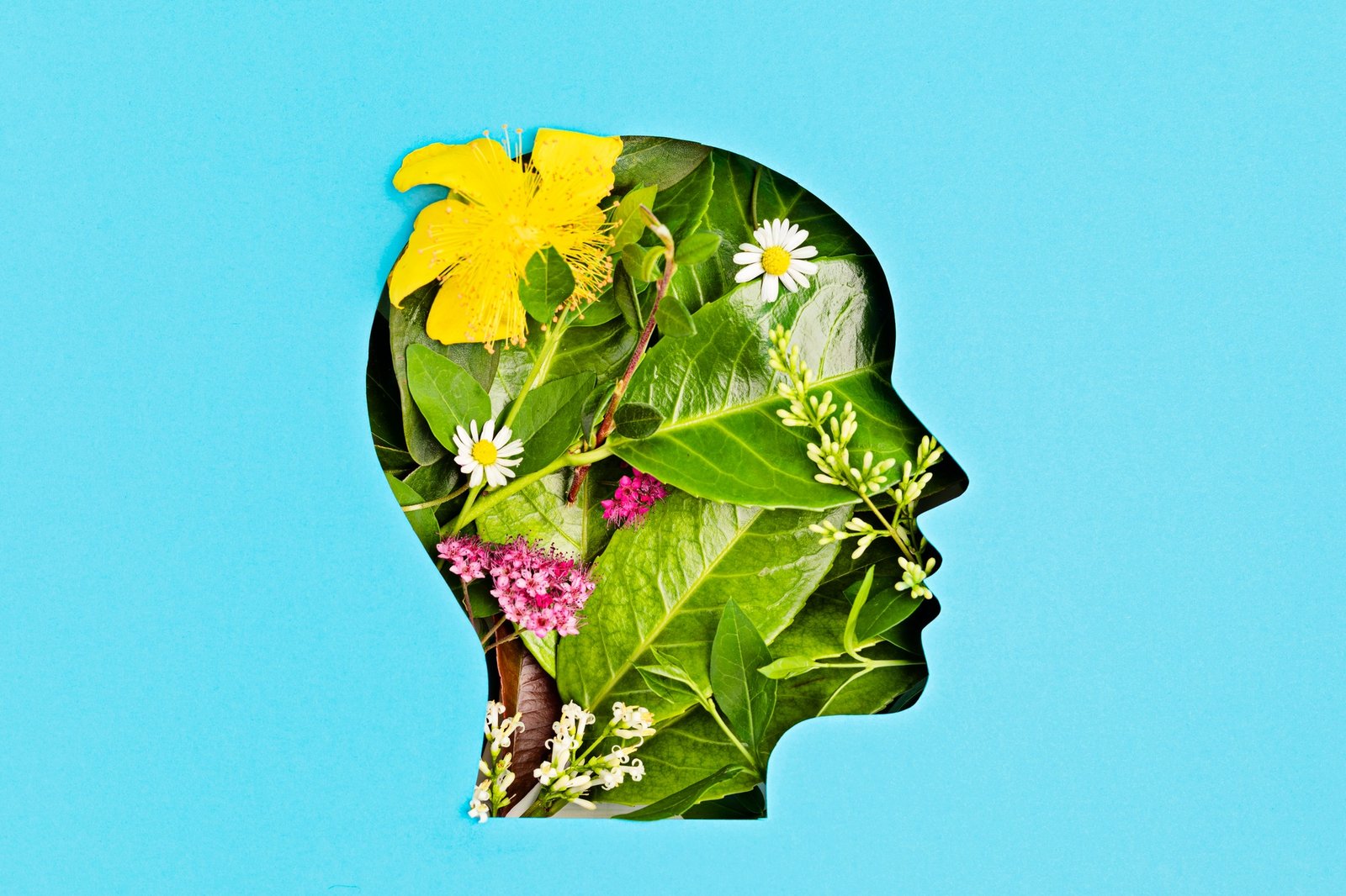 Papercut head with green leaves and flowers. Mental health, emotional wellness, contented emotions