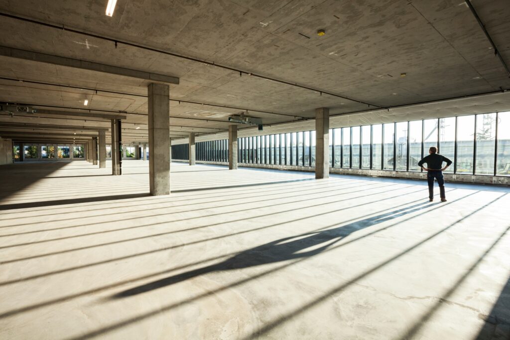 Single businessman in new empty raw business space for a new office